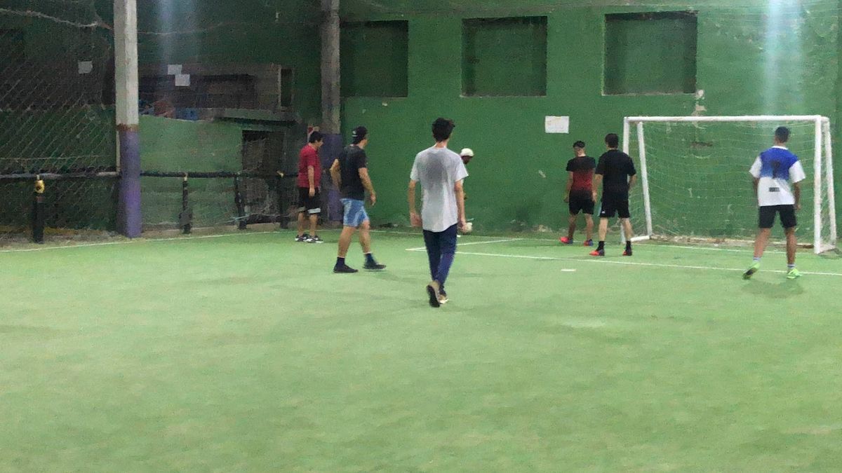 Partido de fútbol en cancha techada de césped sintético